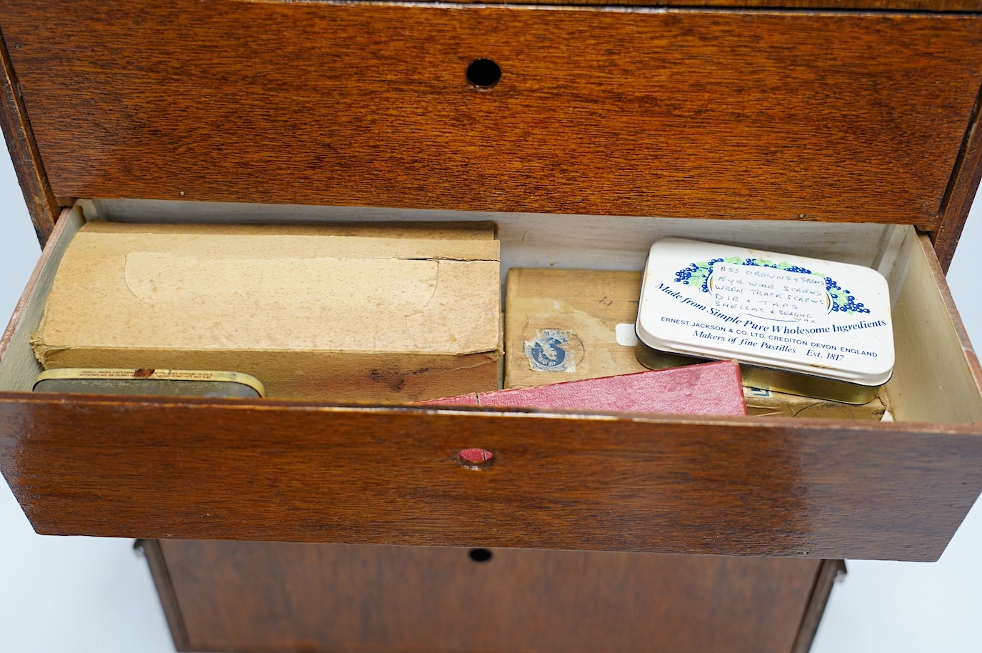 A collection of watch parts, tools and a small selection of costume jewellery, housed in two cases, together with two books. Condition - poor to fair